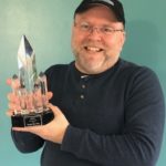 Shawn Merwin holding his Lifetime Achievement Award from Fantasy Con